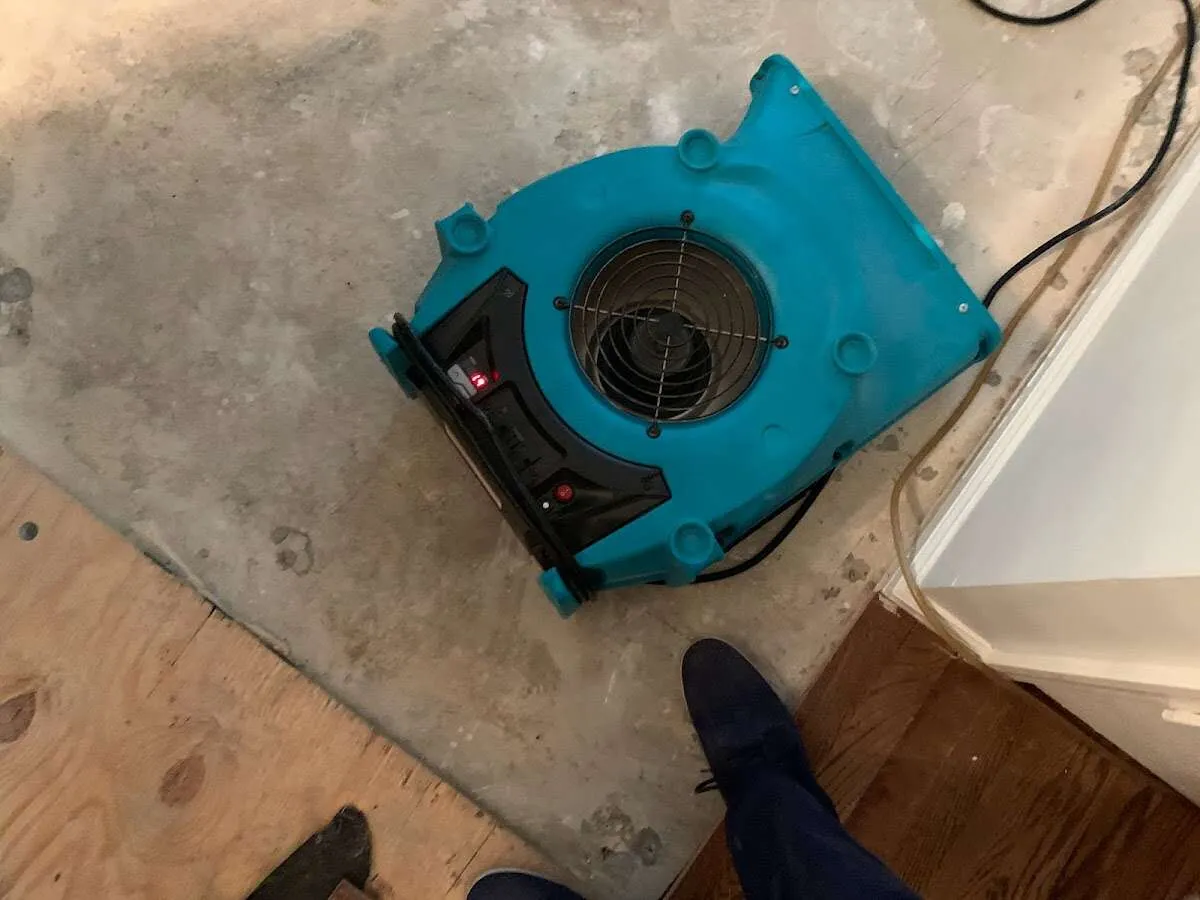 Air mover drying subfloor during Commercial Water Damage Restoration in Booneville